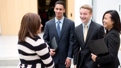 students in business suits talking with an employer